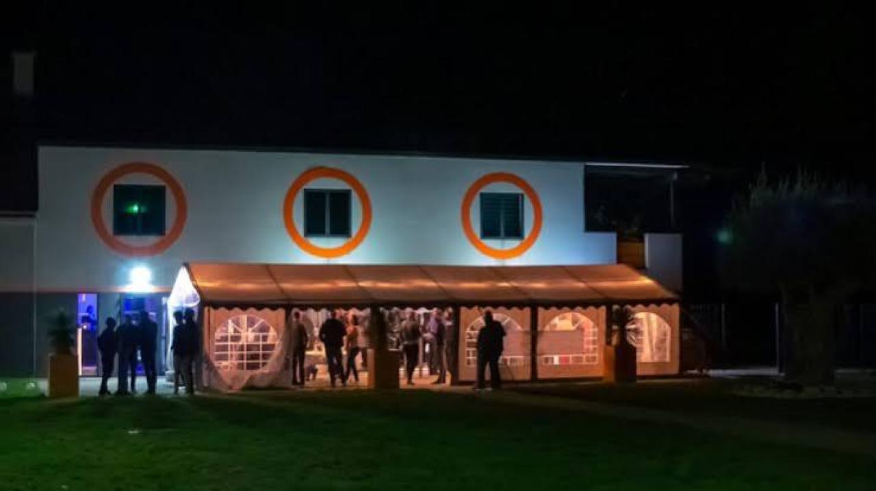 Le Domaine de l'Aéropiste illuminé de nuit, invités rassemblés sous le chapiteau
